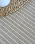 Close-up of an oilcloth with horizontal stripes and a woven mat.