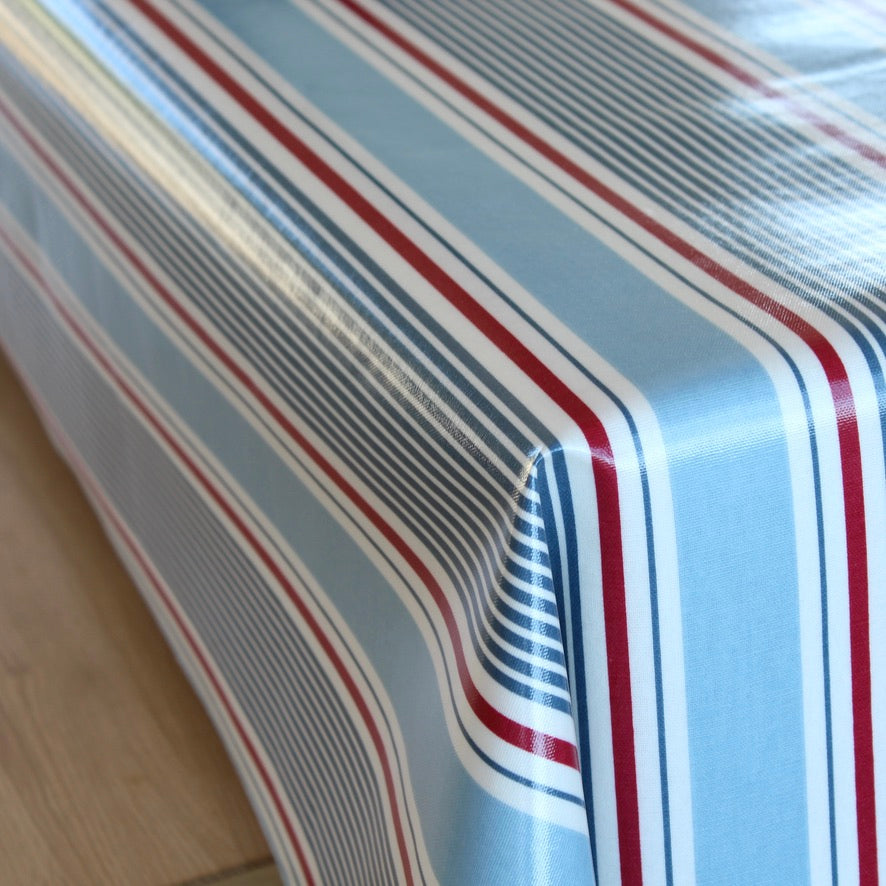 Close-up of a striped oilcloth with red, white, and blue lines on a wooden surface.