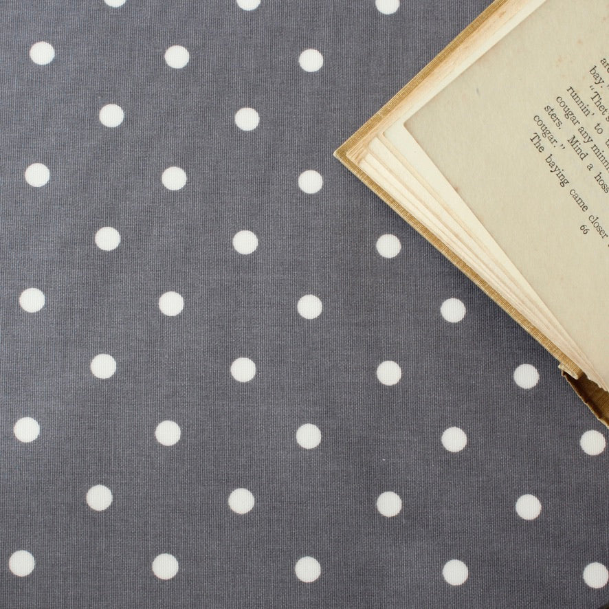 Gray oilcloth with white polka dots and an open book on top