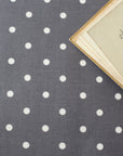 Gray oilcloth with white polka dots and an open book on top