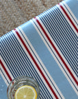 Striped tablecloth with a glass of water and lemon slice with a jute rug