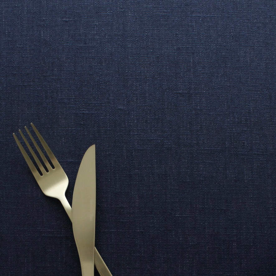 Gold fork and knife on a navy blue tablecloth