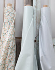 Three oilcloth rolls with different patterns against a wooden background