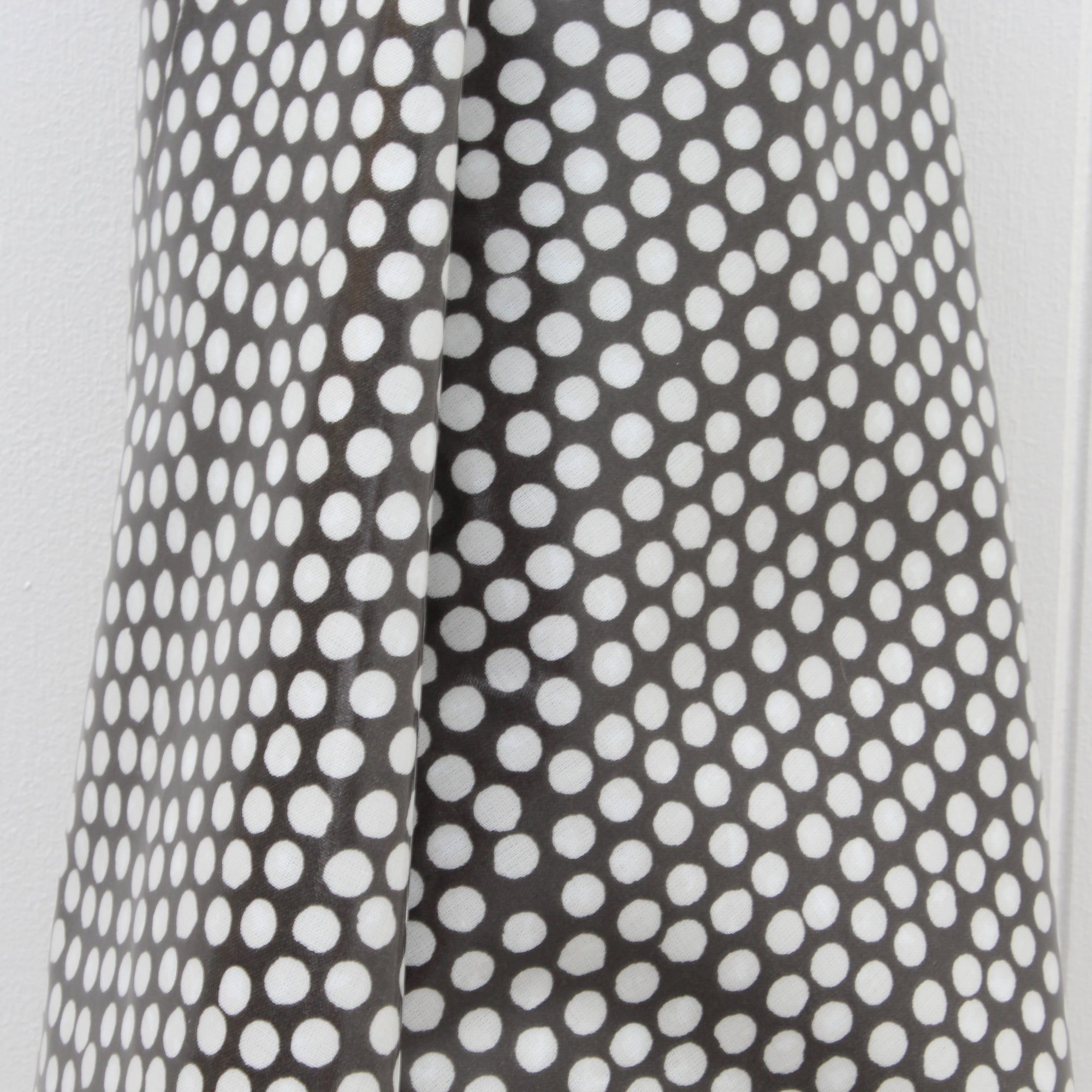 Close-up of an oilcloth with a black and white polka dot pattern.