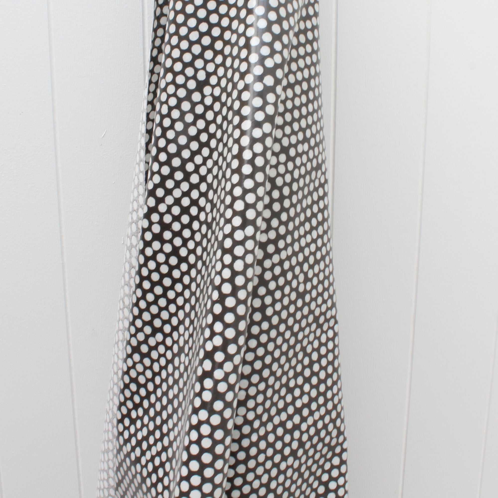 Black and white polka dot oilcloth on a white background