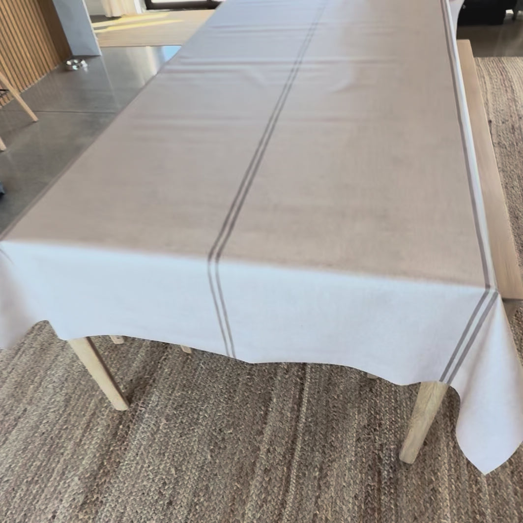 Grainsack design oilcloth with a beige stripe on a wooden table