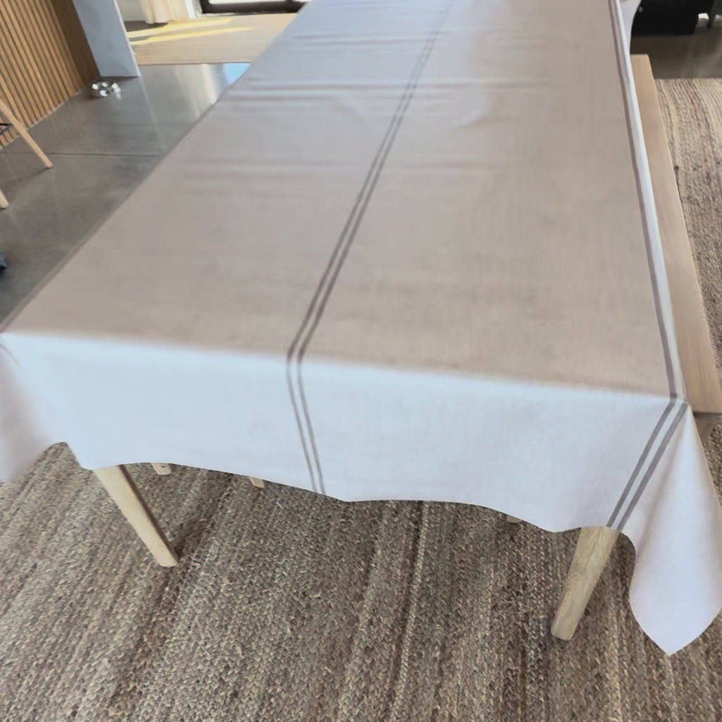 Grainsack design oilcloth with a beige stripe on a wooden table