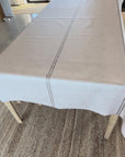 Grainsack design oilcloth with a beige stripe on a wooden table