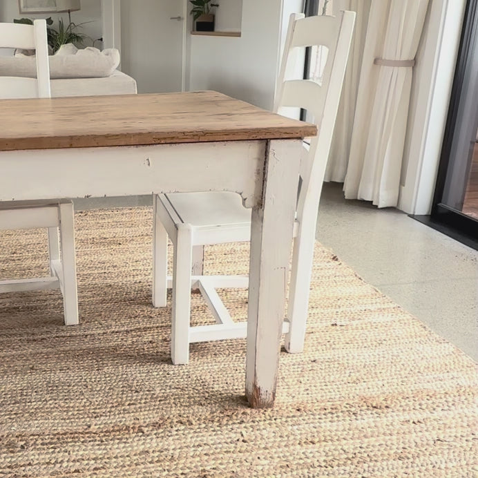 white wipeable linen tablecloth being put on a wooden table