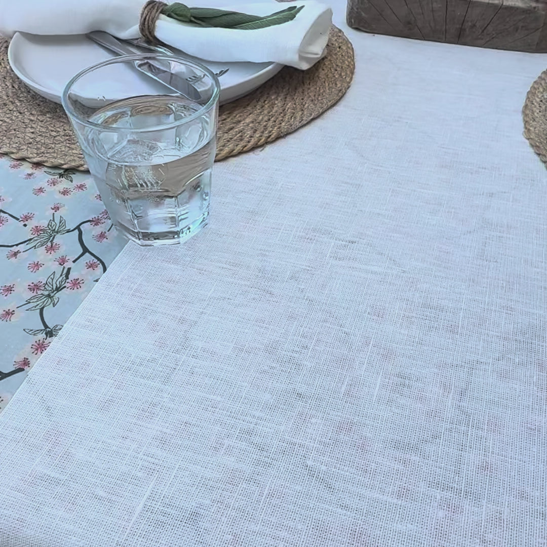 water glass being spilt onto white linen table cloth and being wiped up easily
