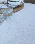 water glass being spilt onto white linen table cloth and being wiped up easily