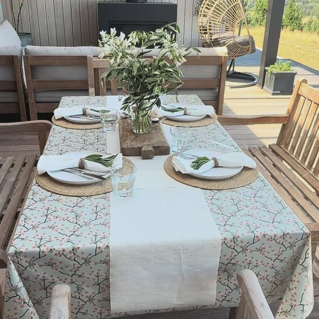 blue floral tablecloth in an outdoor dining area with a white table runner
