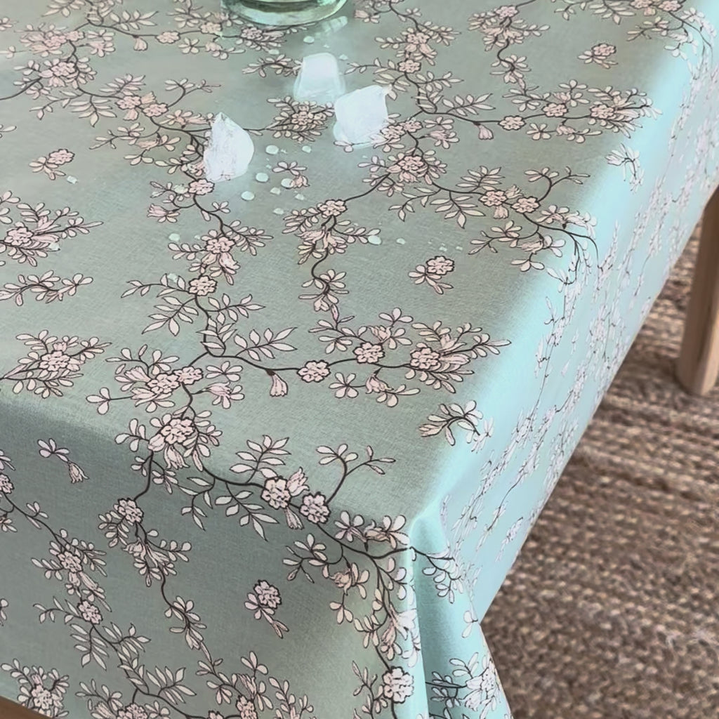 video of a floral oilcloth with ice cubes being wiped off it
