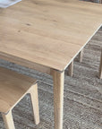 Wooden table being covered with a striped blue white and beige tablecloth