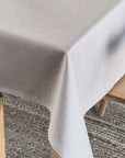 Beige coloured wipeable linen tablecloth on a wooden table
