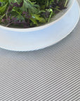 video of olive oil being spilled onto a stripe grey tablecloth then wiped away