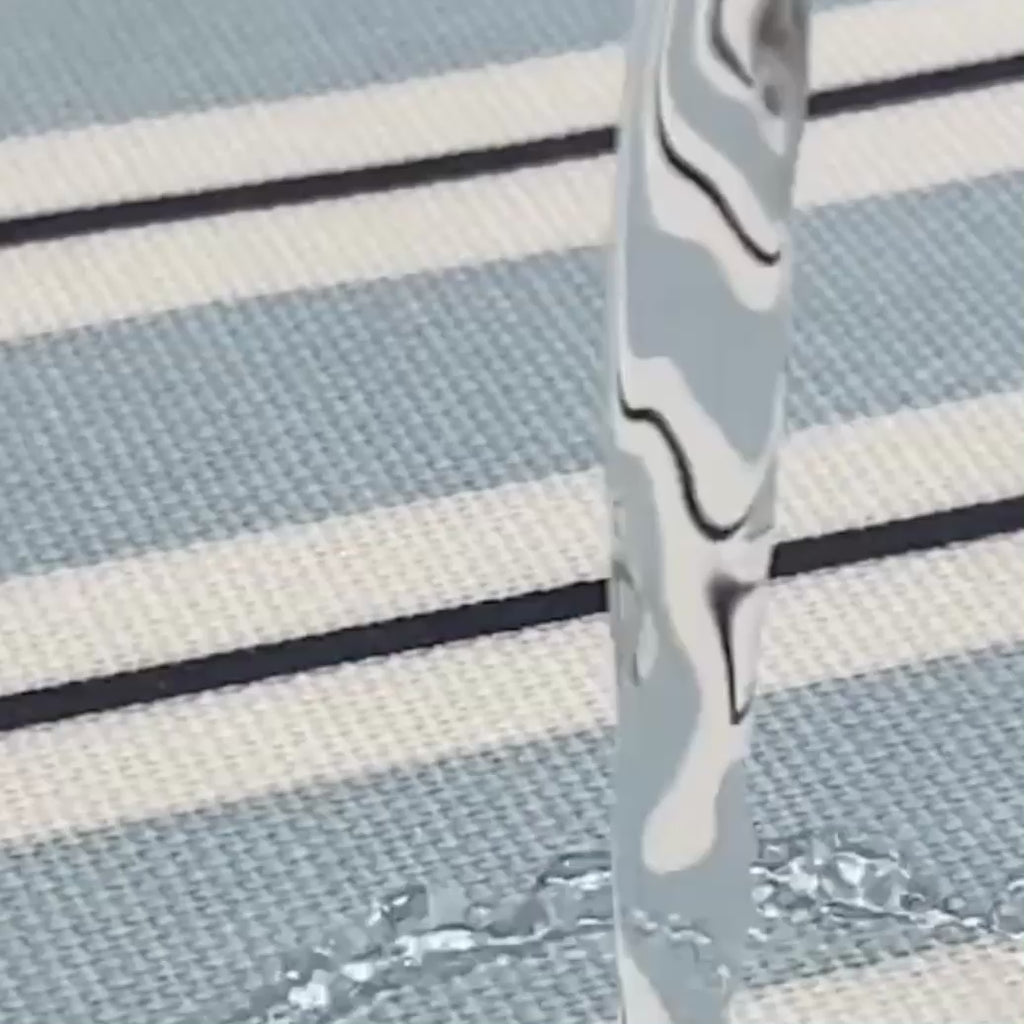 water being poured ono a wipe clean blue and white striped tablecloth