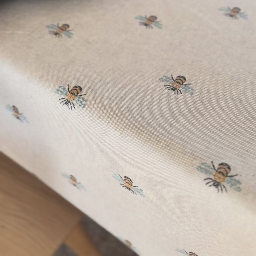 video of a tablecloth with a bees pattern and a earthy coloured plate 
