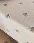 video of a tablecloth with a bees pattern and a earthy coloured plate 