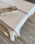 Grainsack design tablecloth with red stripes on a beige background.