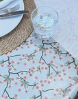 blue floral oilcloth on an outdoor table with a glass of water being spilled then wiped up easily