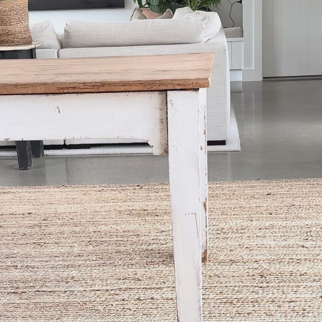 grey stripe oilcloth being put on a rustic wooden table